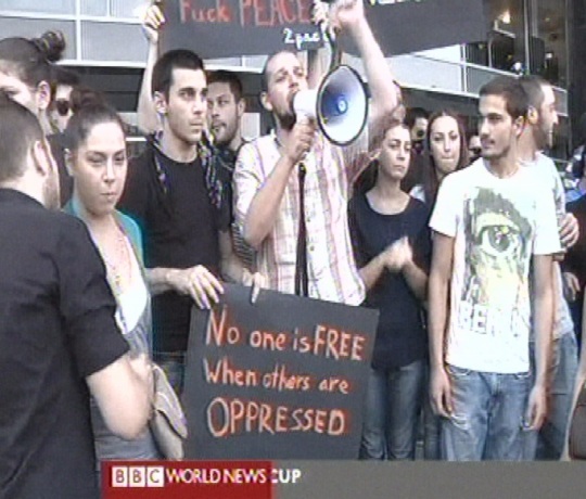BBC uudised kell 10.22 opositsiooni meeleavaldus ja plakat kirjaga: "Mitte keegi pole vaba kui kedagi teist rõhutakse".